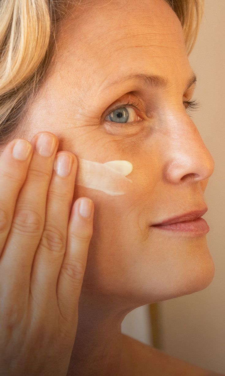 Mujer aplicándose crema facial